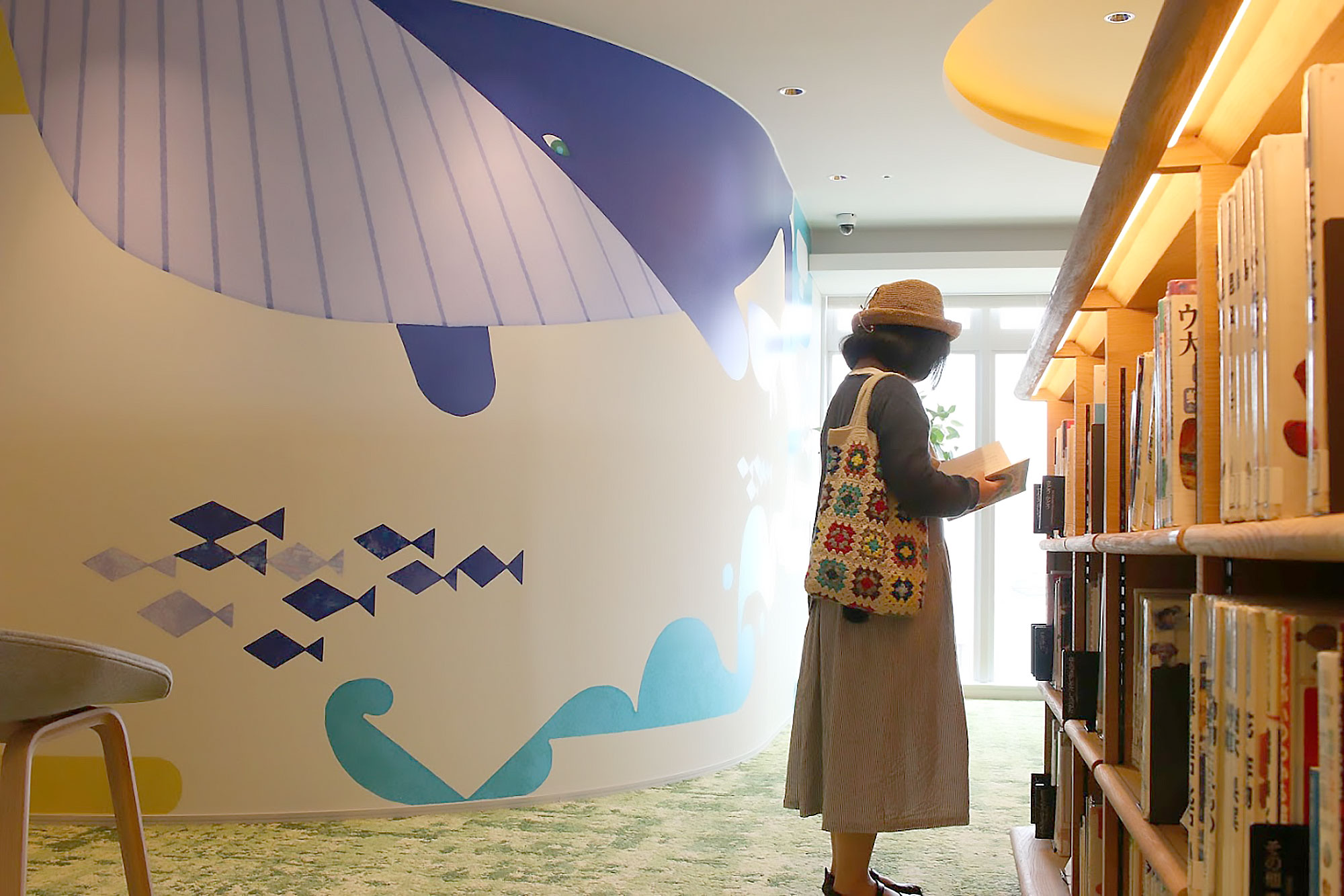 和歌山市民図書館で読書をする女性を見守るくじら親子